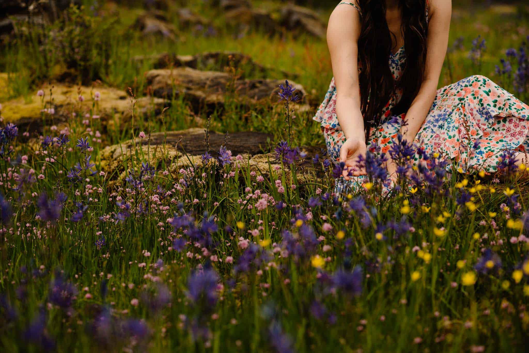 woman reaching arms out in ceremony to wild flowers
