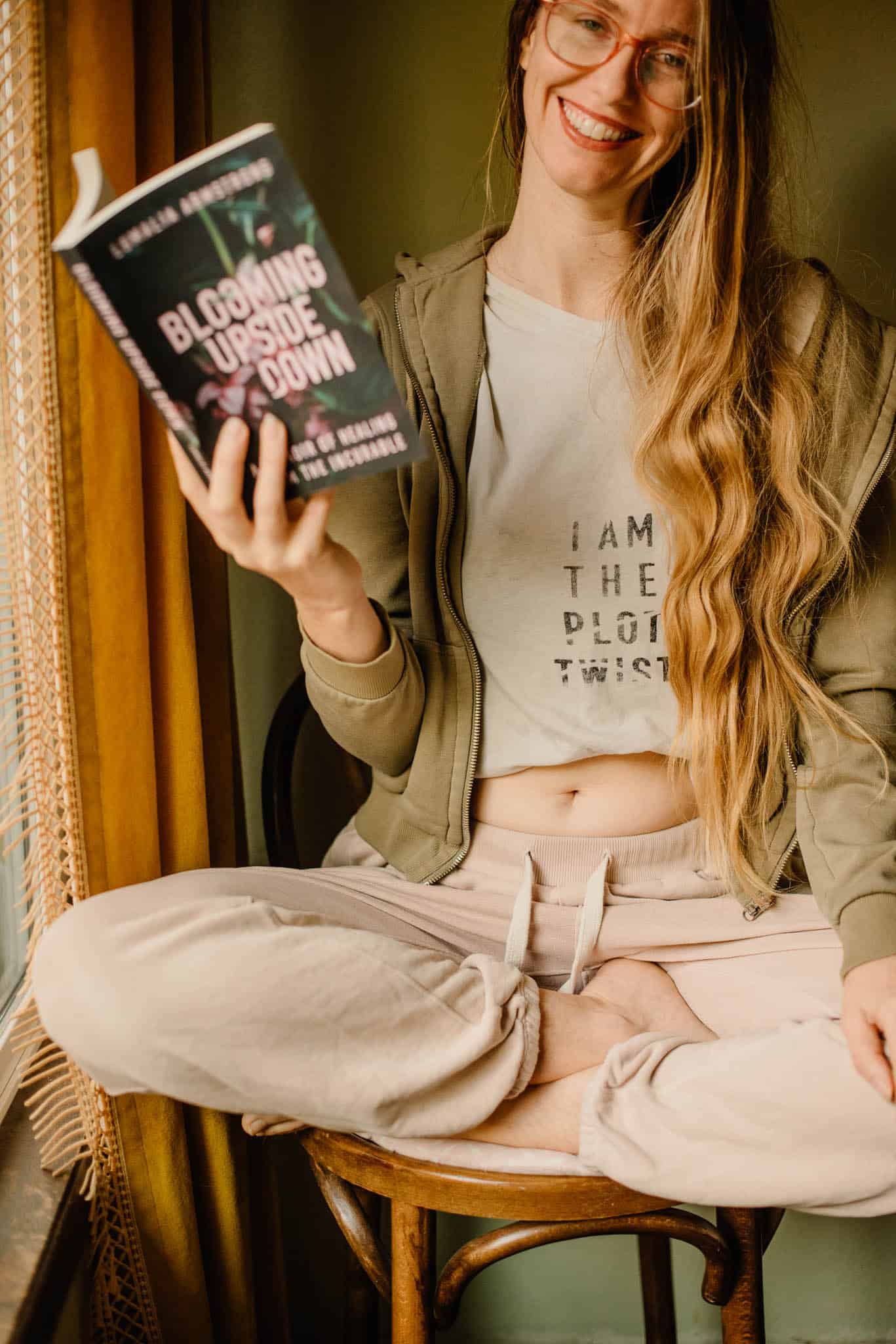 Lumalia with her book a "I am the plot twist " shirt