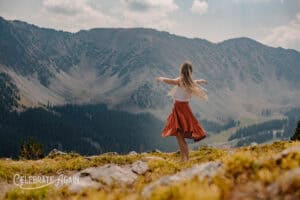 woman in mountian spinning on how to feel alive without blowing up your life in red dress