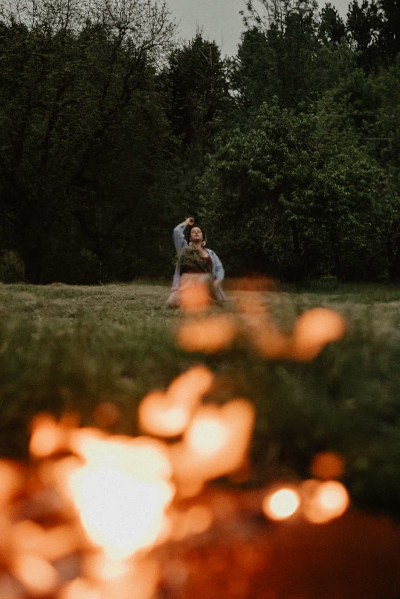 woman laying in ground releasing rage during a rage retreat in oregon with a fire in the forground