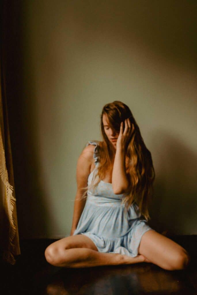 Lumalia moving through feelings of being in the messy middle of life on the floor in a self portrait dancing